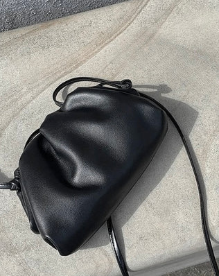 Zoe Clutch i sort vegansk læder med blød og rummelig konstruktion, aftagelig skulderrem og elegant design fotograferet på grå baggrund. Tasken har en halvmåneformet silhuet med smuk tekstur. Alle produkter, Tasker, Bestsellers, Nyheder, New products, Bestsellers 2, Lædertasker (vegansk)